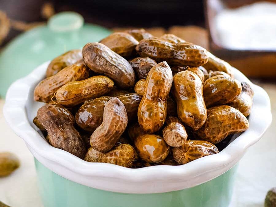 Boiled peanuts in a bowl with a salt bowl in the background.