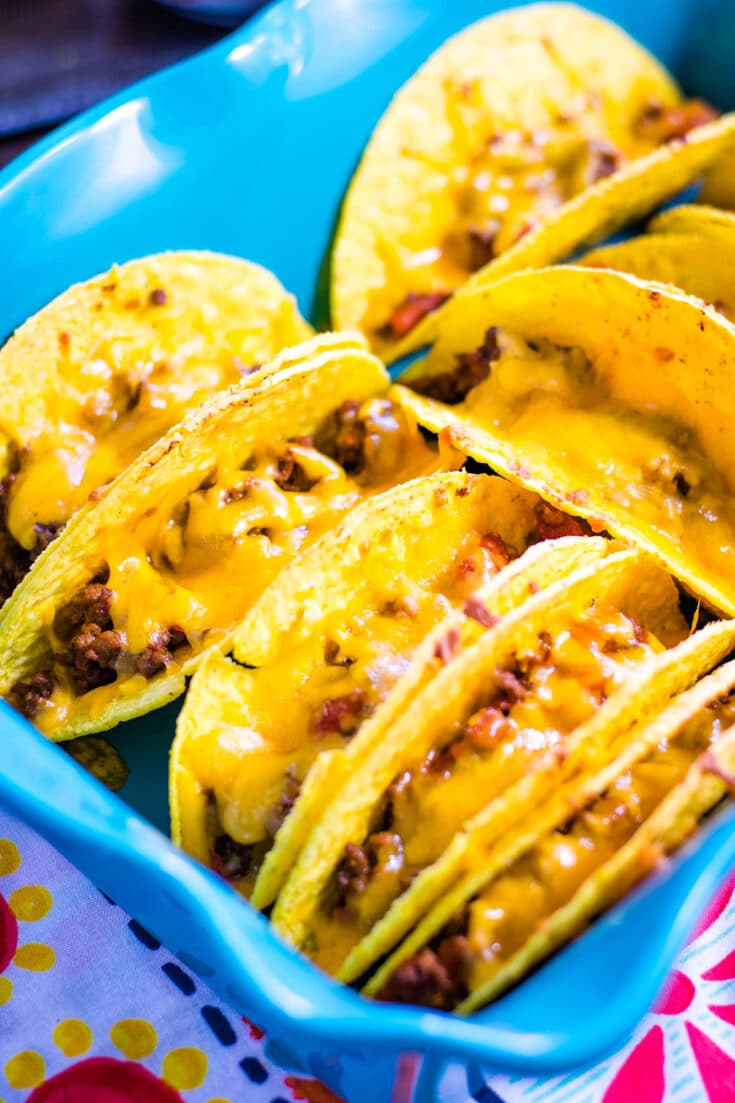 A blue baking dish with baked tacos.