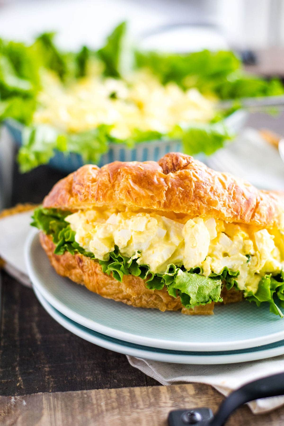 Egg salad with a lettuce leaf on a croissant roll.