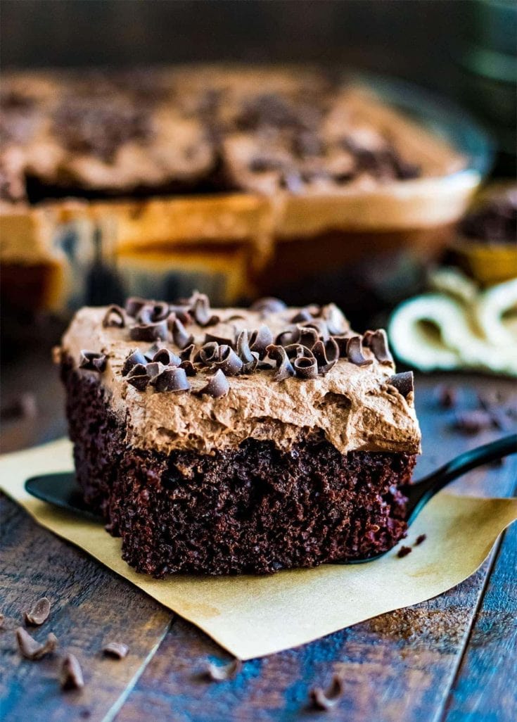 Slice of triple chocolate mousse cake topped with chocolate curls