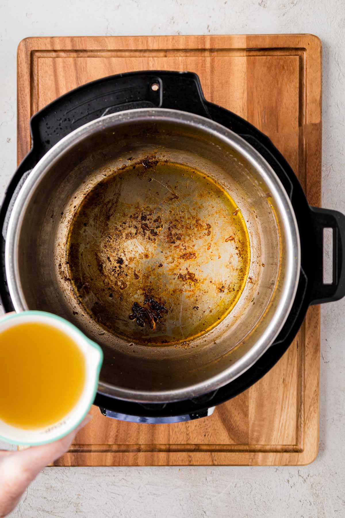 Pour a cup of chicken broth into inner pot of instant pot.