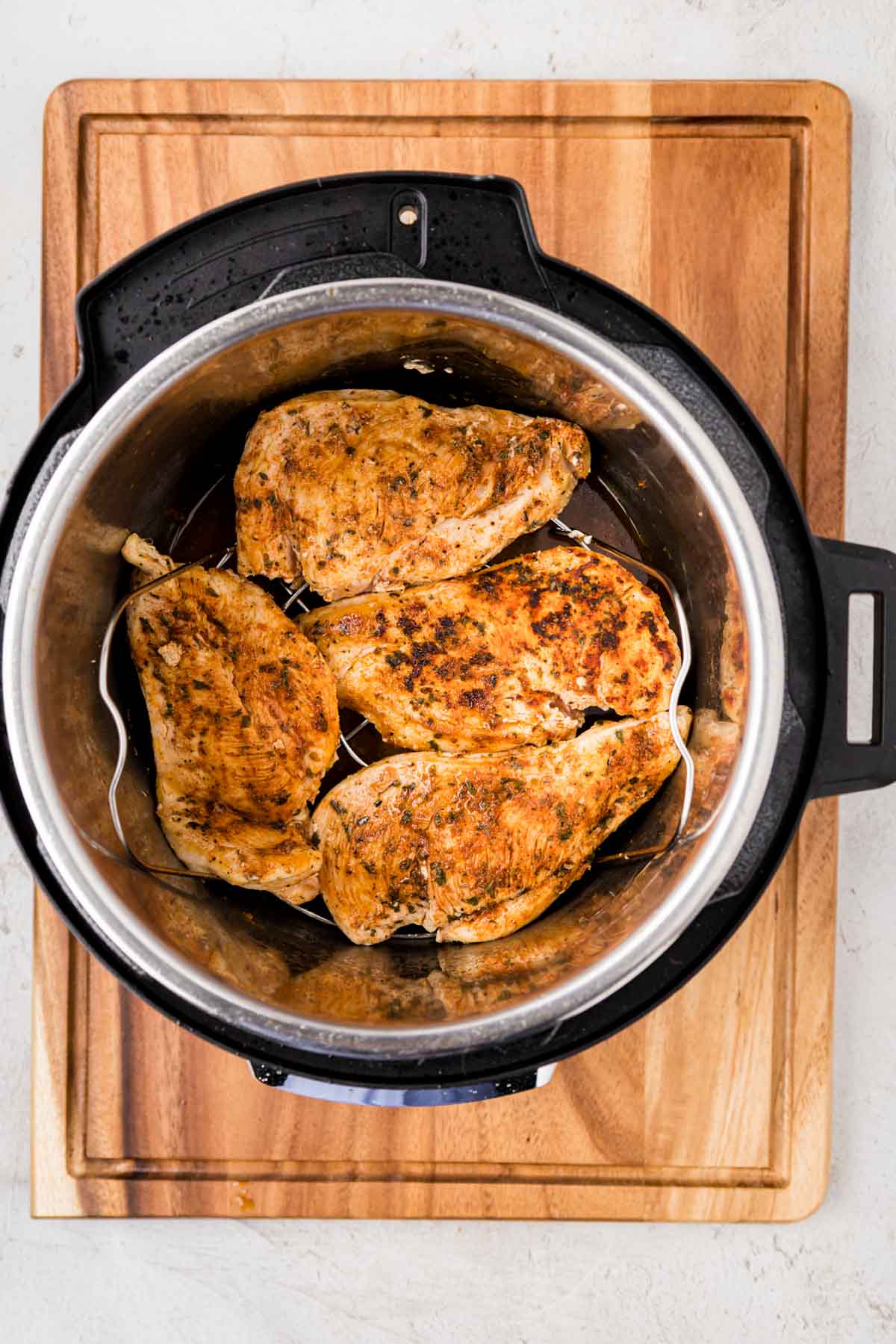Chicken added on top of trivet in instant pot in a single layer.