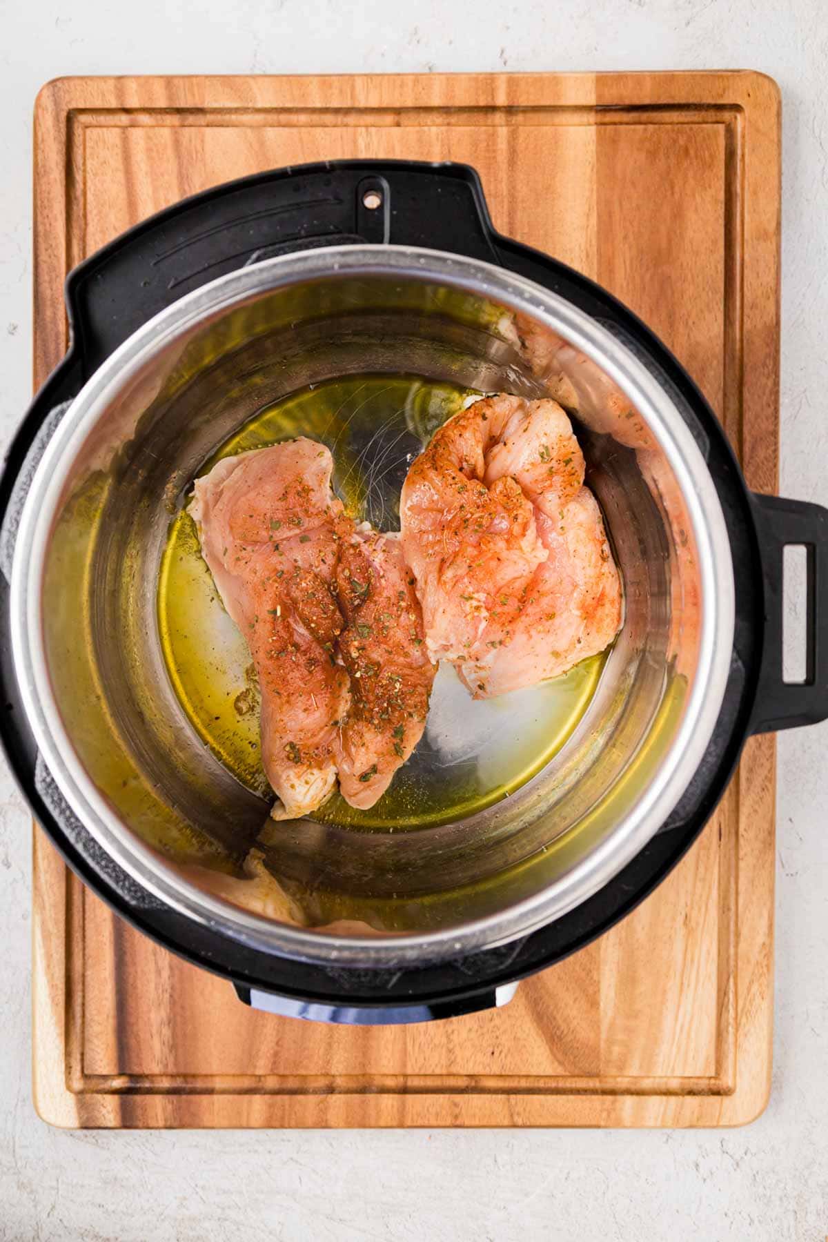 Seasoned chicken in the instant pot to sauté.
