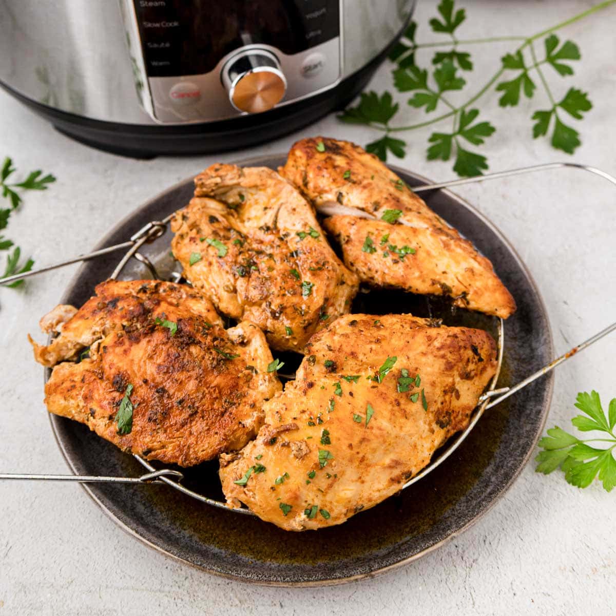 Cooked instant pot chicken resting on a plate.