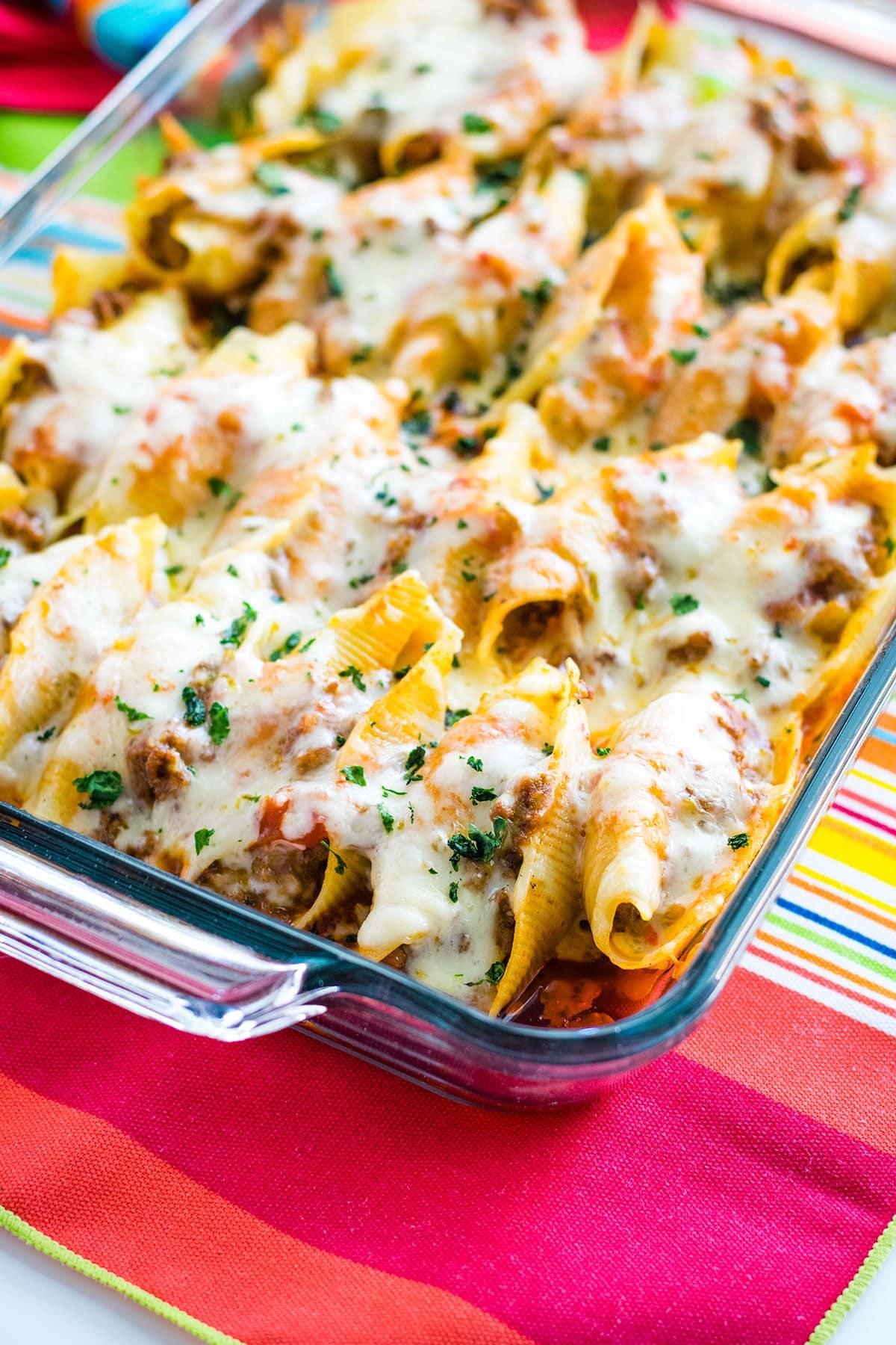 A close-up of Mexican stuffed shells topped with melted cheese.