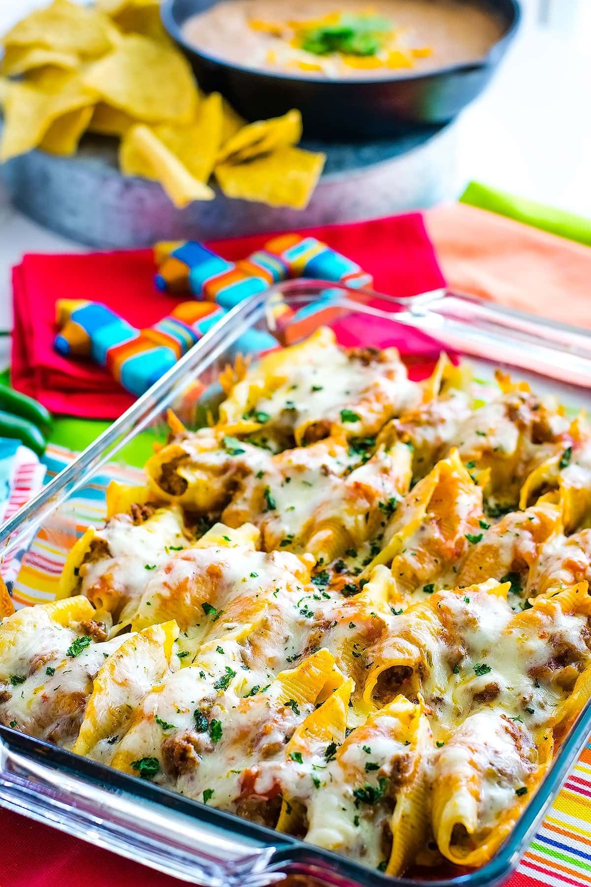 A clear baking dish filled with Mexican stuffed shells.