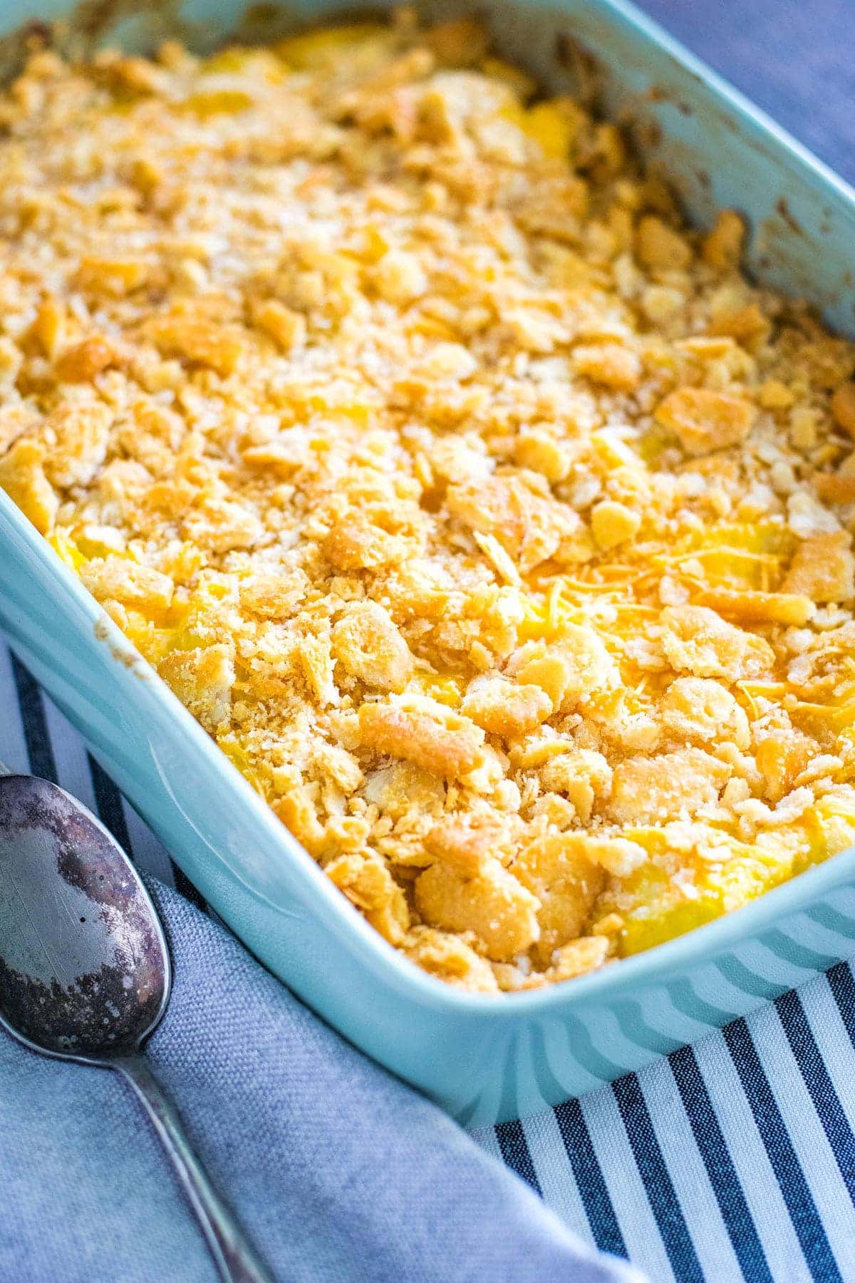 an overhead view of this cheesy yellow squash casserole in a light blue baking dish