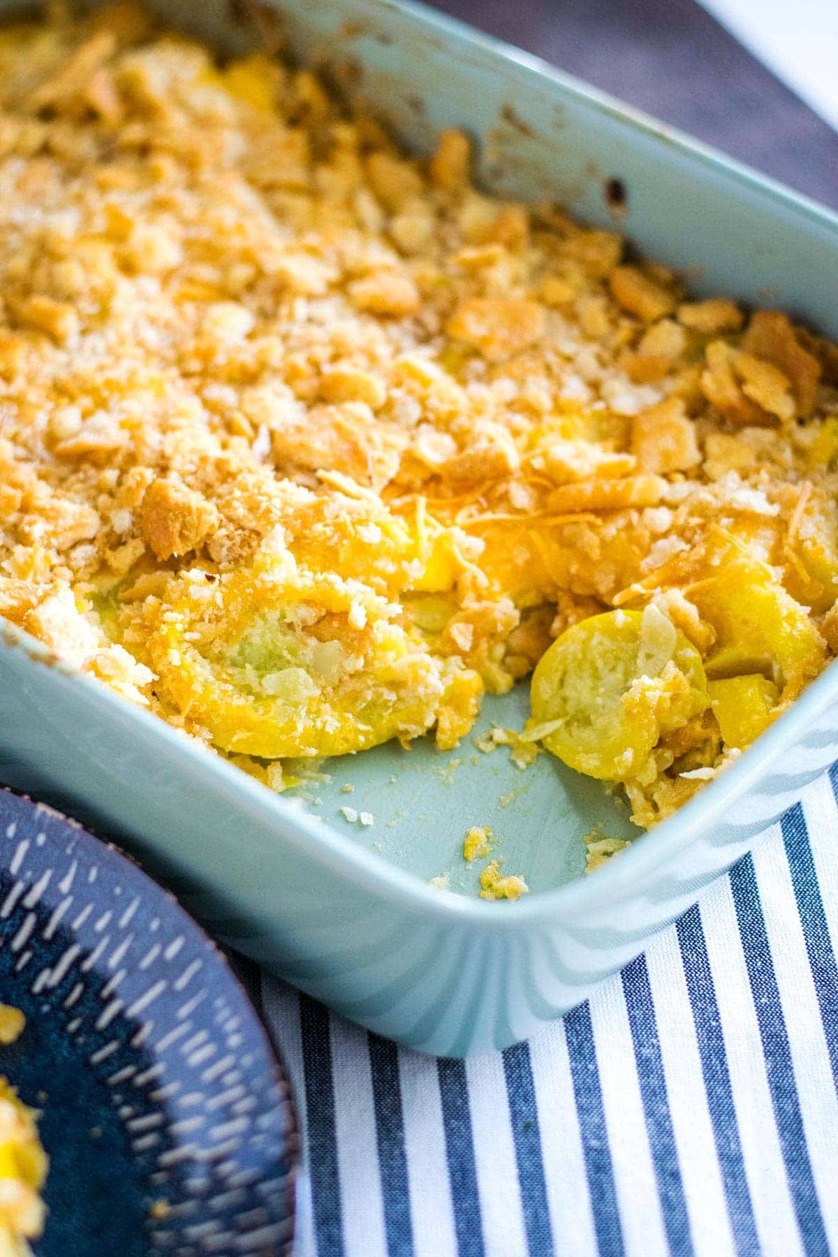 an overhead view of this cheesy yellow squash casserole in a light blue baking dish