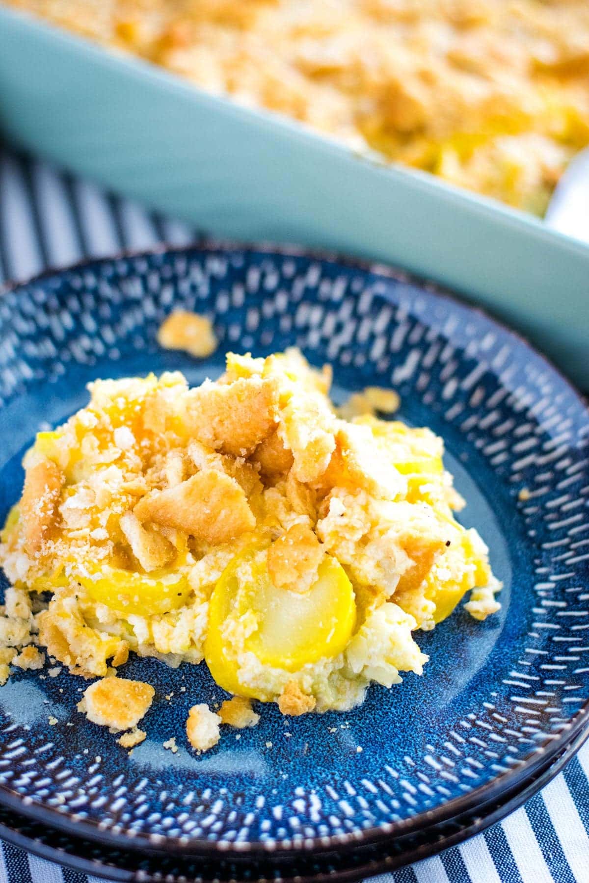a blue plate with a serving of this cheesy yellow squash casserole