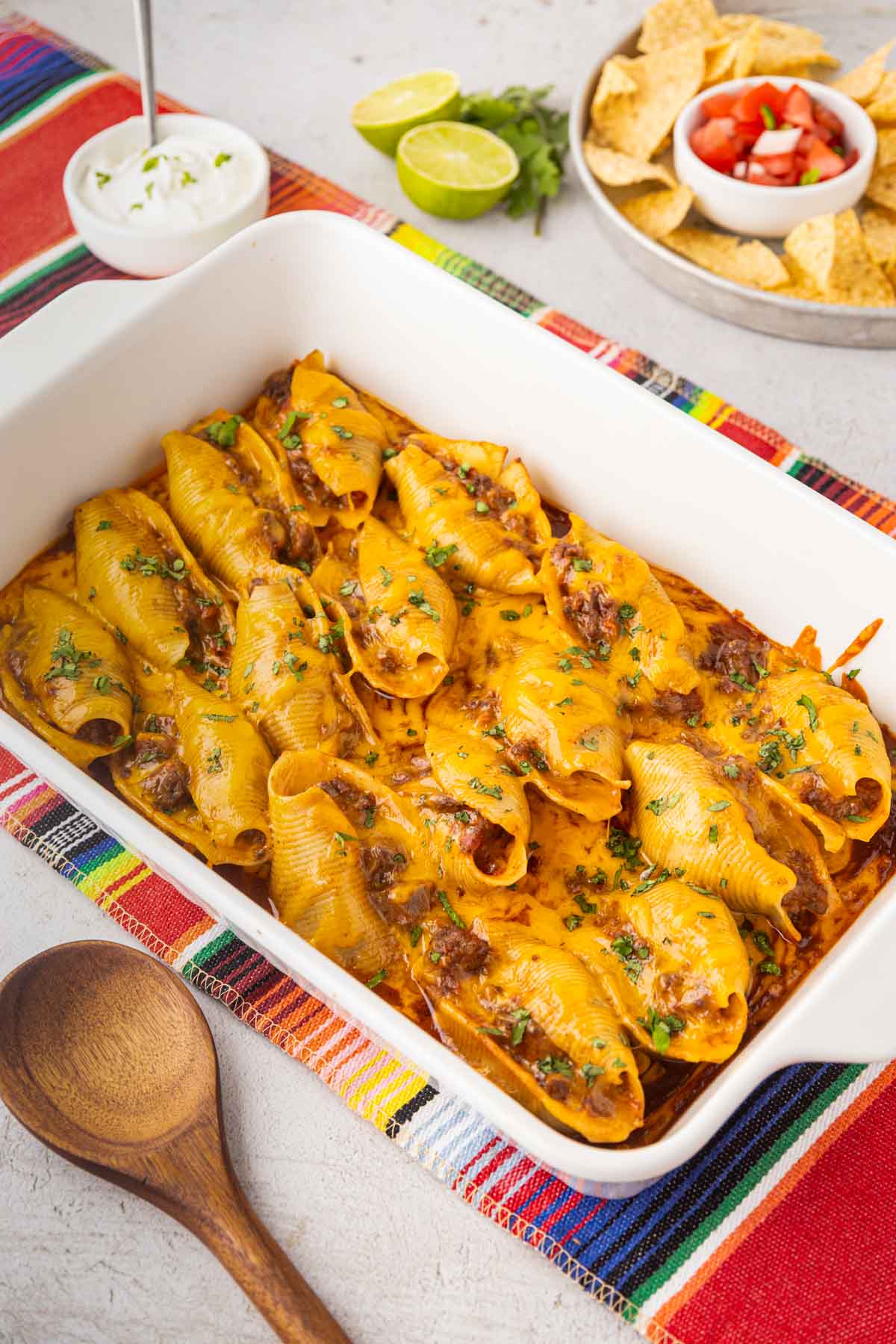 A casserole dish filled with cheesy Mexican stuffed shells.