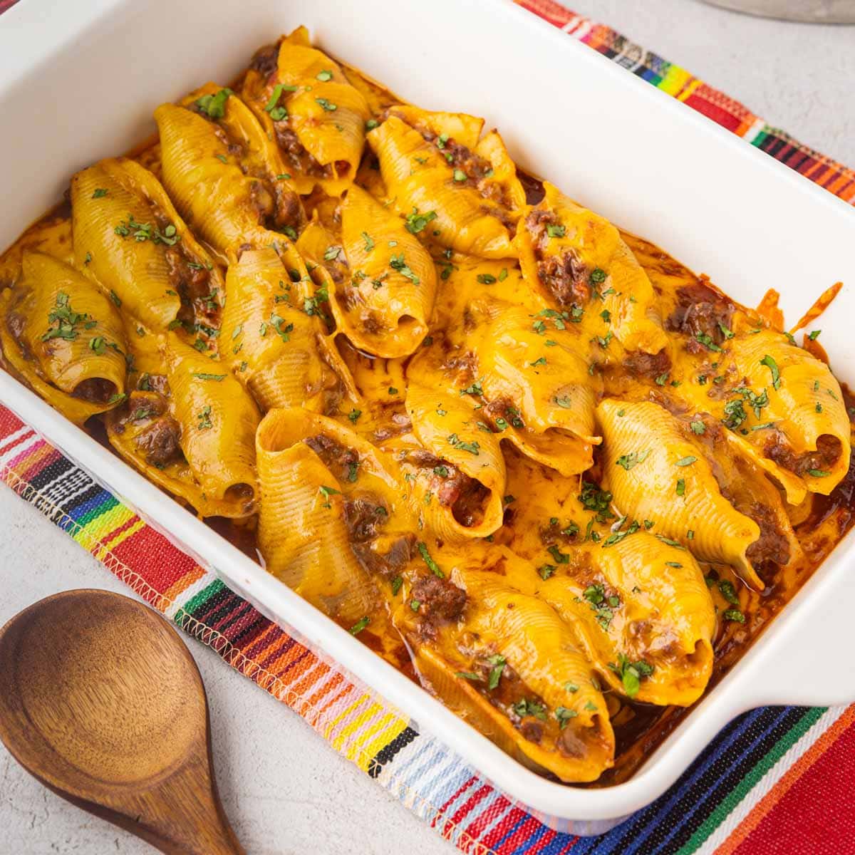 A casserole dish filled with cheesy Mexican stuffed shells.
