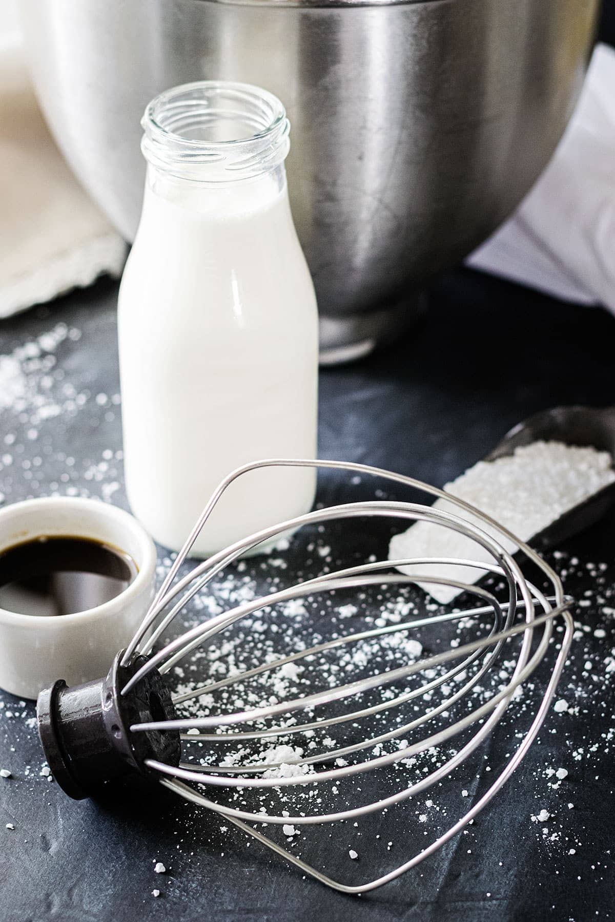 A chilled metal bowl, heavy cream, vanilla and a whisk. All the ingredients for homemade whipped cream.