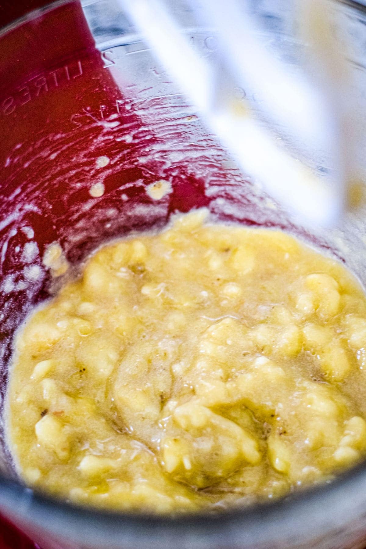 mashed bananas in a glass mixing bowl