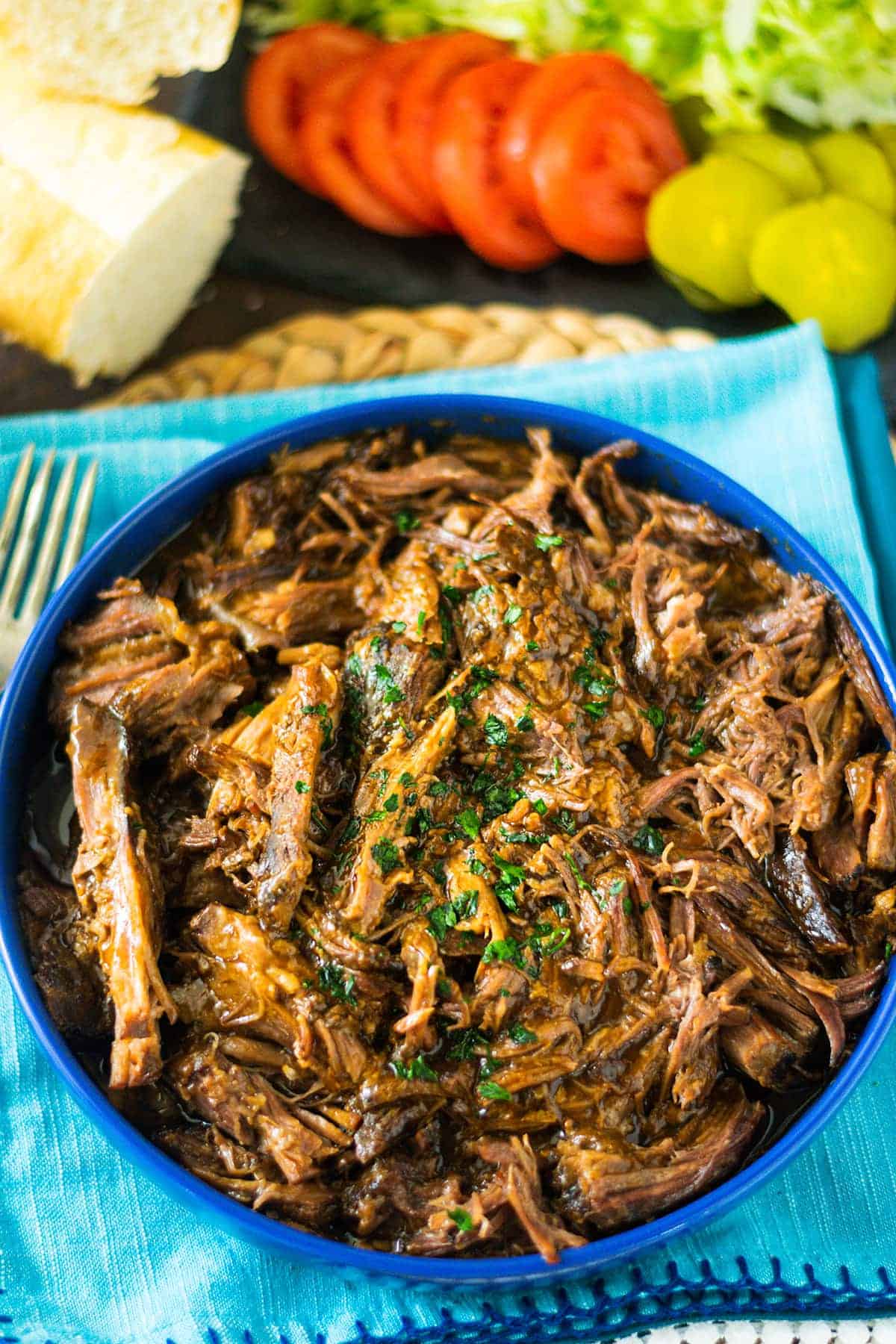 A bowl of roast beef debris on a blue plate.