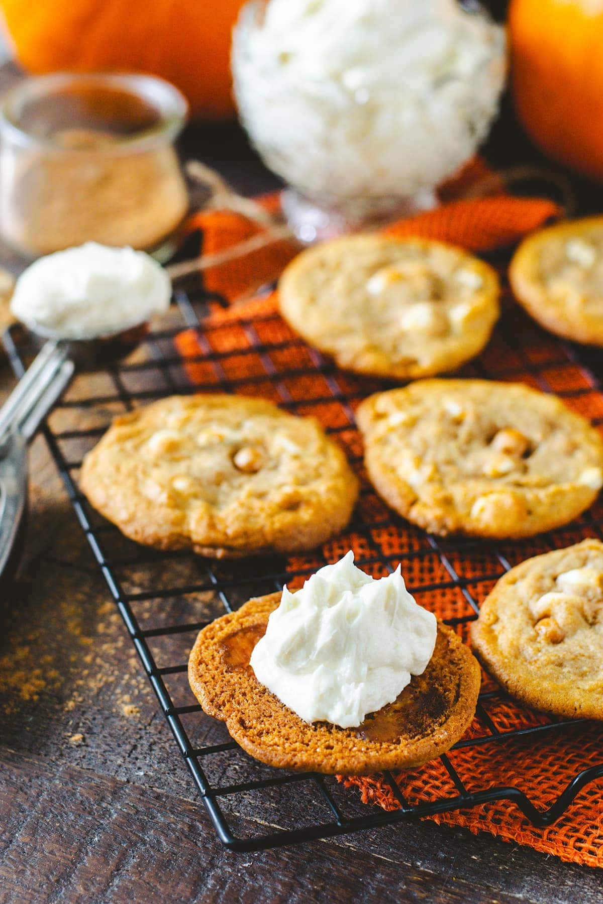 white chocolate caramel pumpkin spice cookies being filled with buttercream icing 