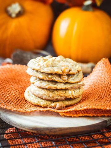 a stack of white chocolate caramel pumpkin spice cookies on a festive Halloween table scape