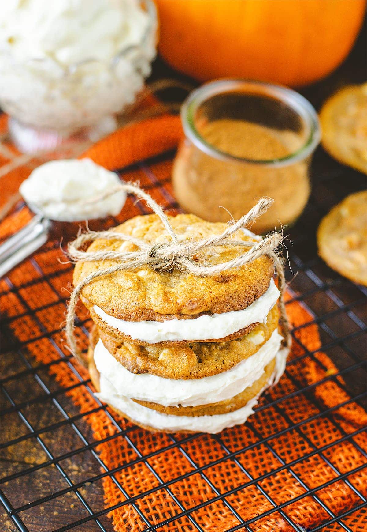 A stack of pumpkin spice sandwich cookies tied with twine ribbon.