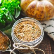 A close-up of turkey rub in a mason jar on a wooden tray.