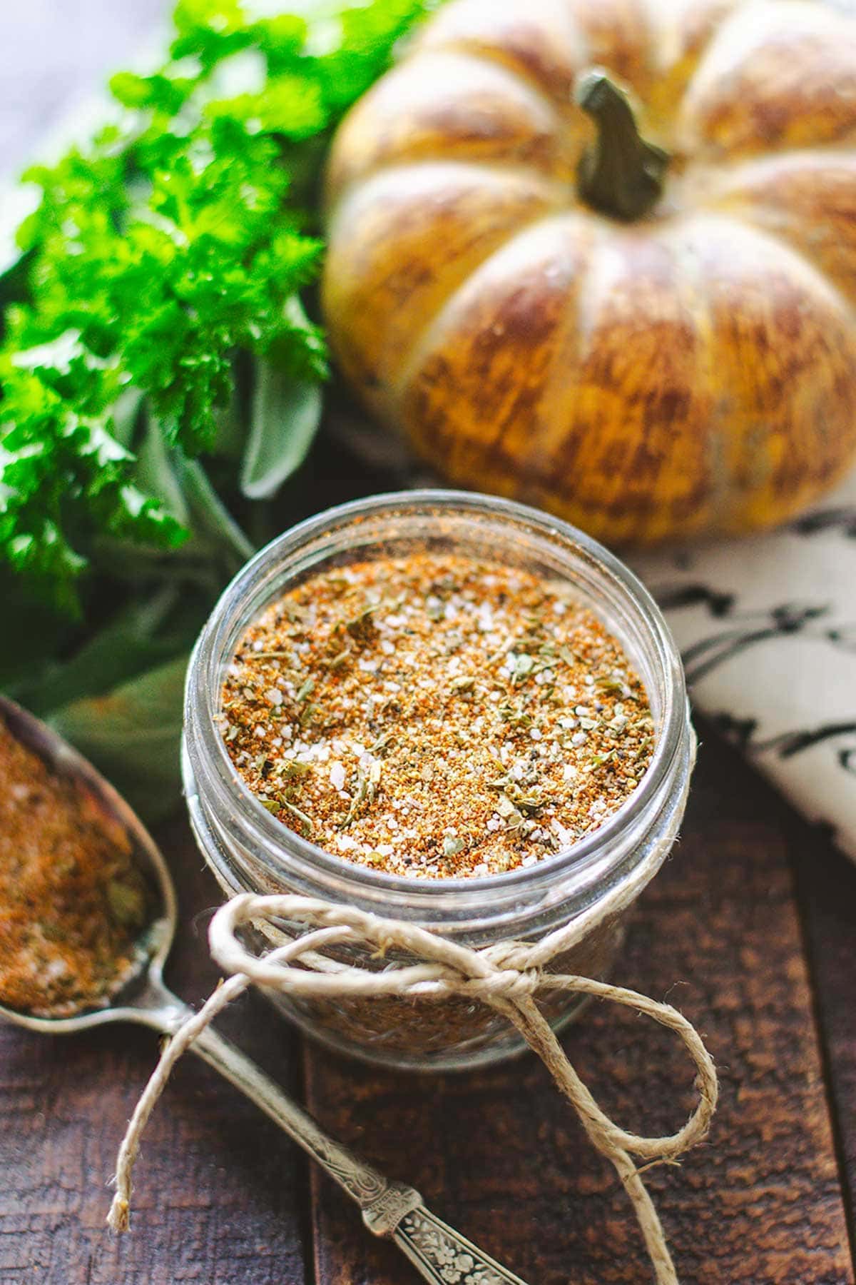 A close-up of turkey rub in a mason jar on a wooden tray.