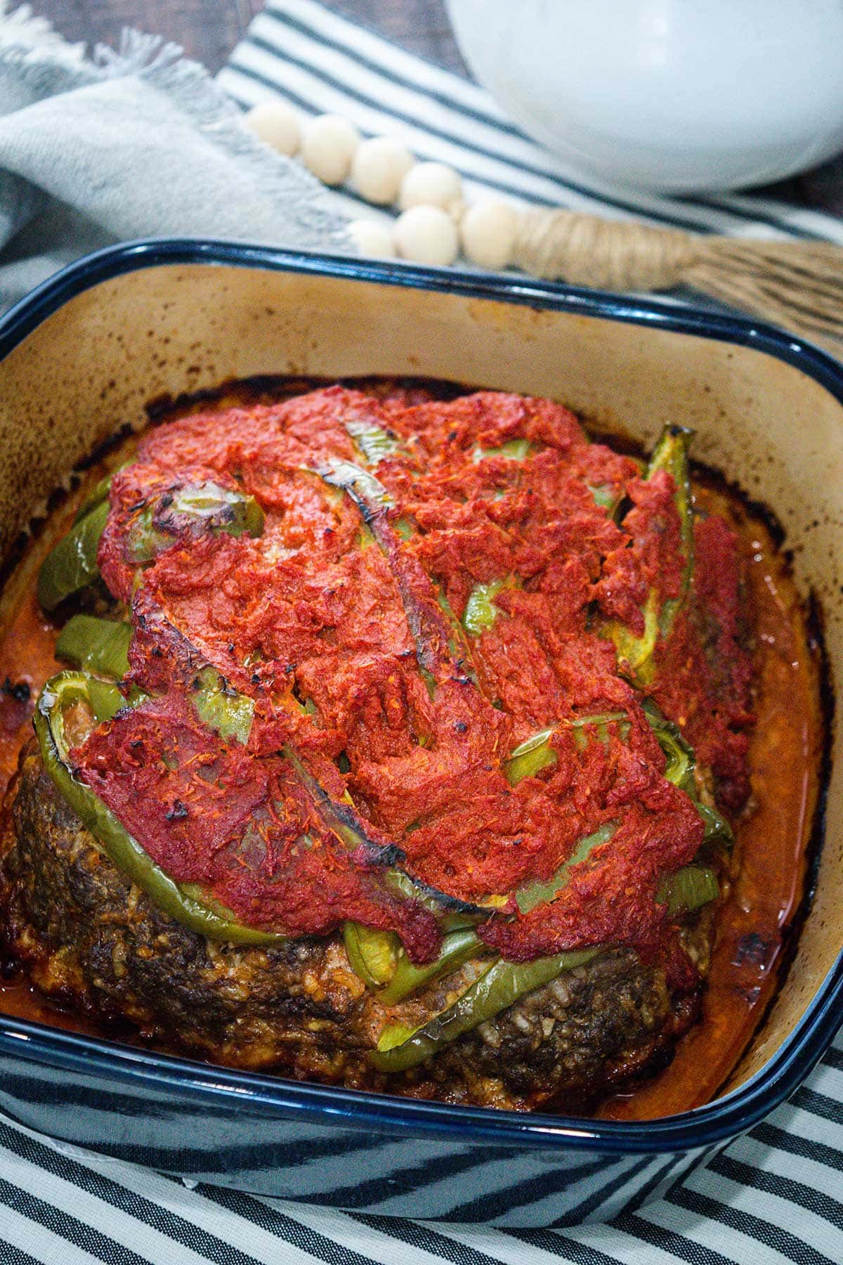 Fresh out of the oven meatloaf in a blue stoneware baking dish.