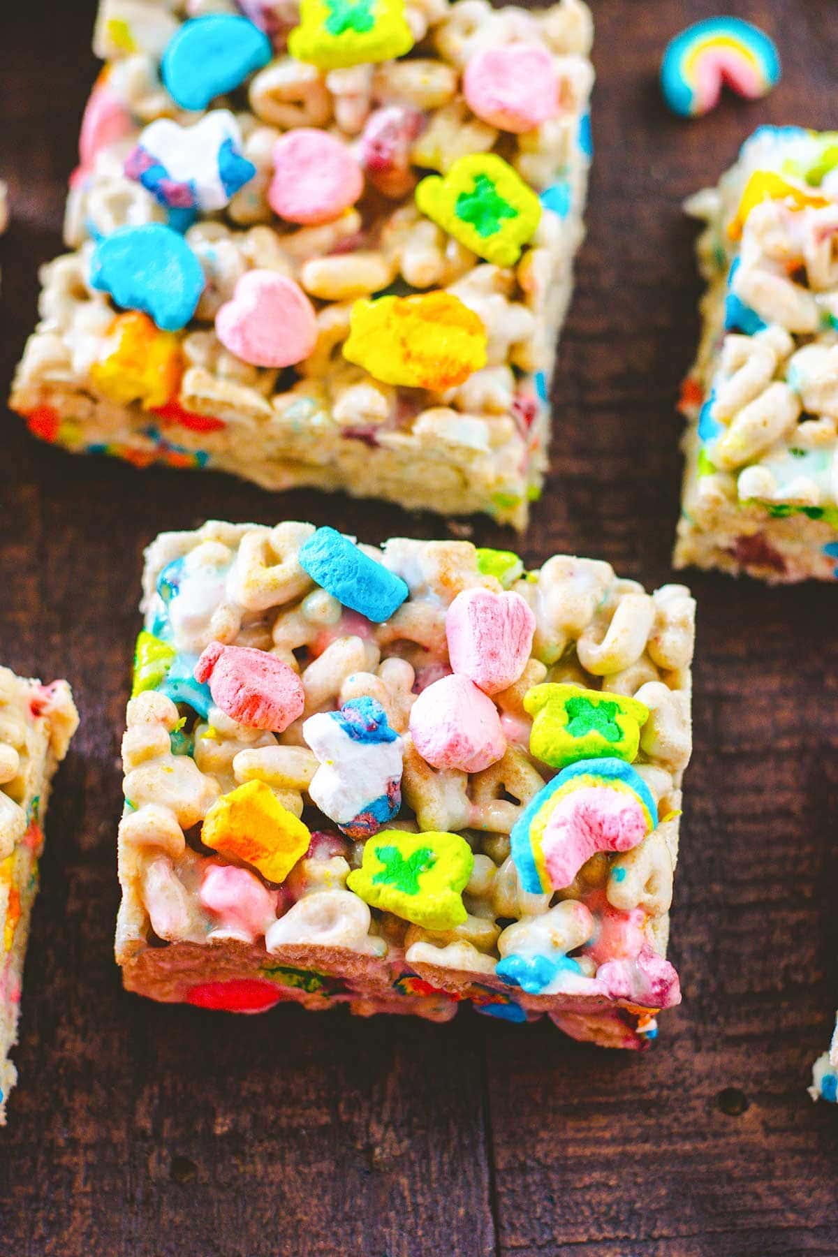 Sliced Lucky Charms treats on a wooden tray.