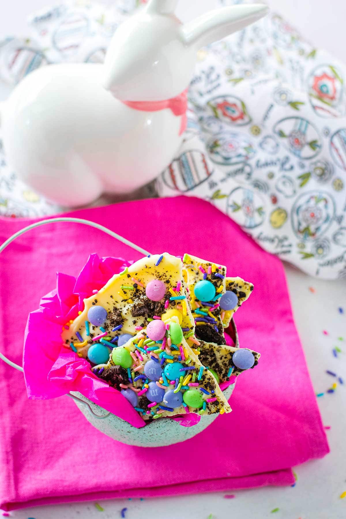 White Chocolate Oreo bark in an egg-shaped bowl on a pink table cloth.