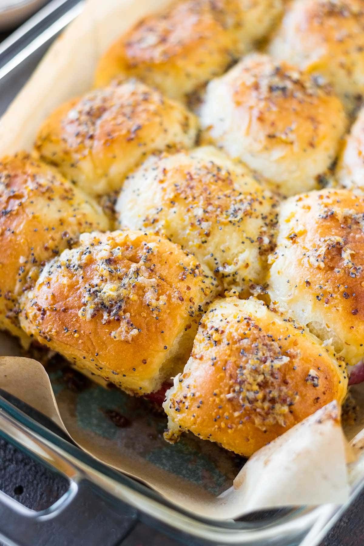 Baking dish of corned beef reuben sliders  with buttery seasoned topping.