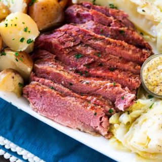 A plate of corned beef with potatoes, carrots, and cabbage.