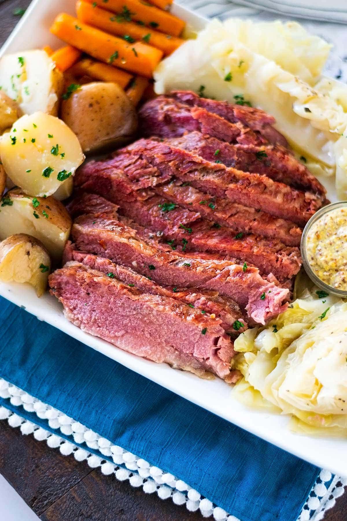 A plate of corned beef with potatoes, carrots, and cabbage. 