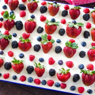 A close-up of a decorated cake with berries on top.