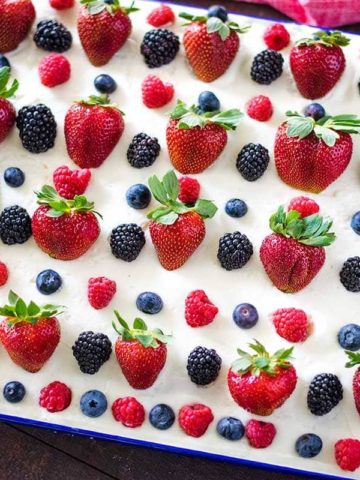 A close-up of a decorated cake with berries on top.