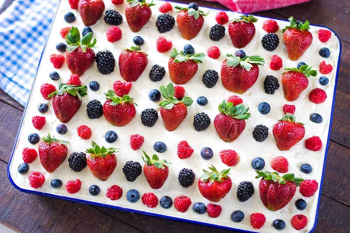 A close-up of a decorated cake with berries on top.