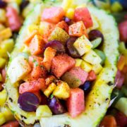 Up close picture of half pineapple filled with Mexican fruit salad.