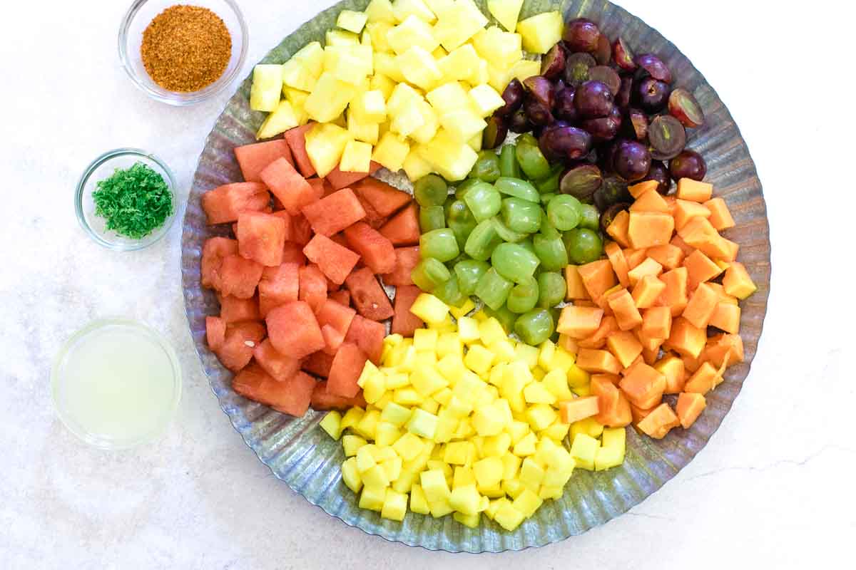 A bowl of fruit on a tray, with fruit salad