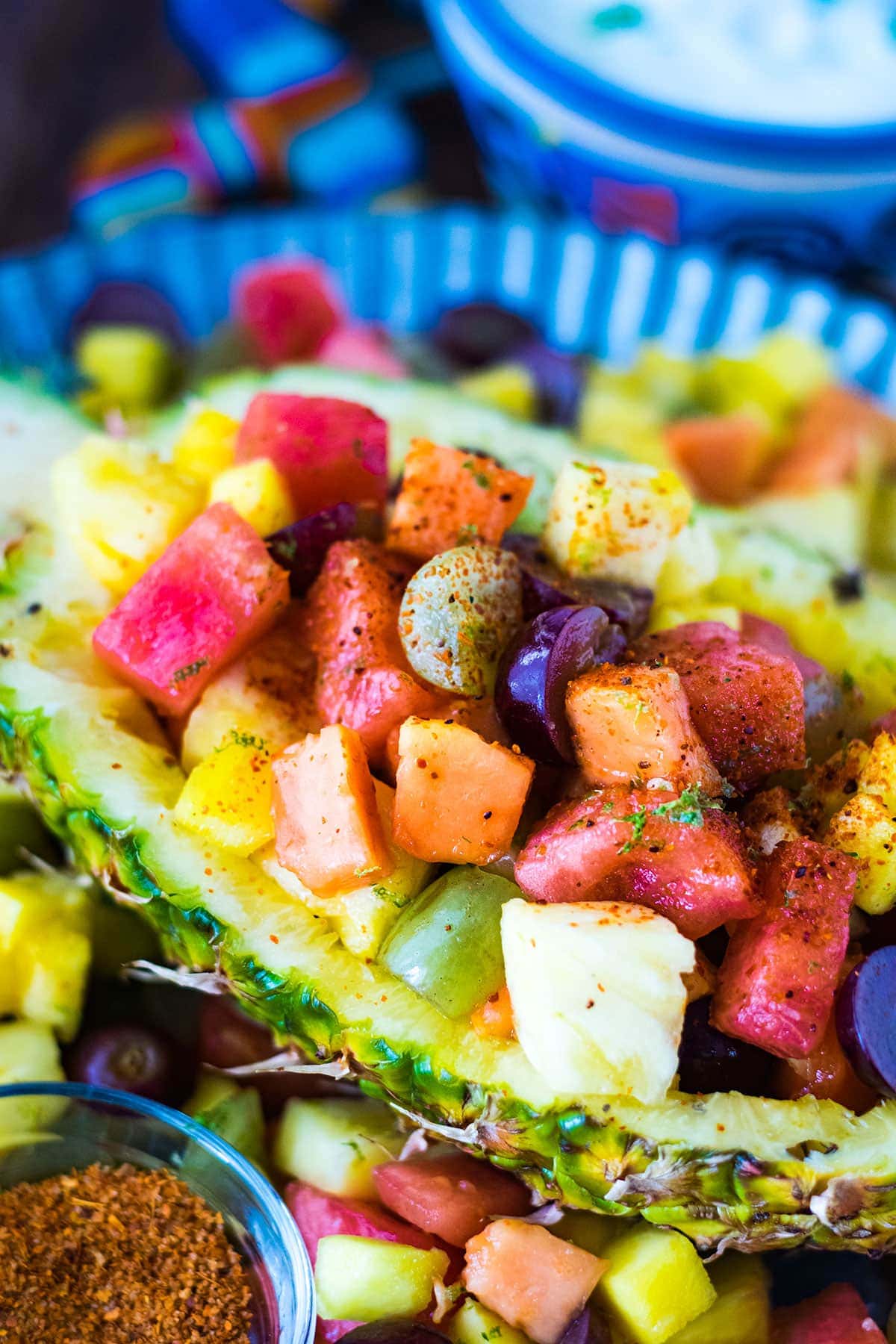 Mexican Fruit salad in a half pineapple on a galvanized tray.