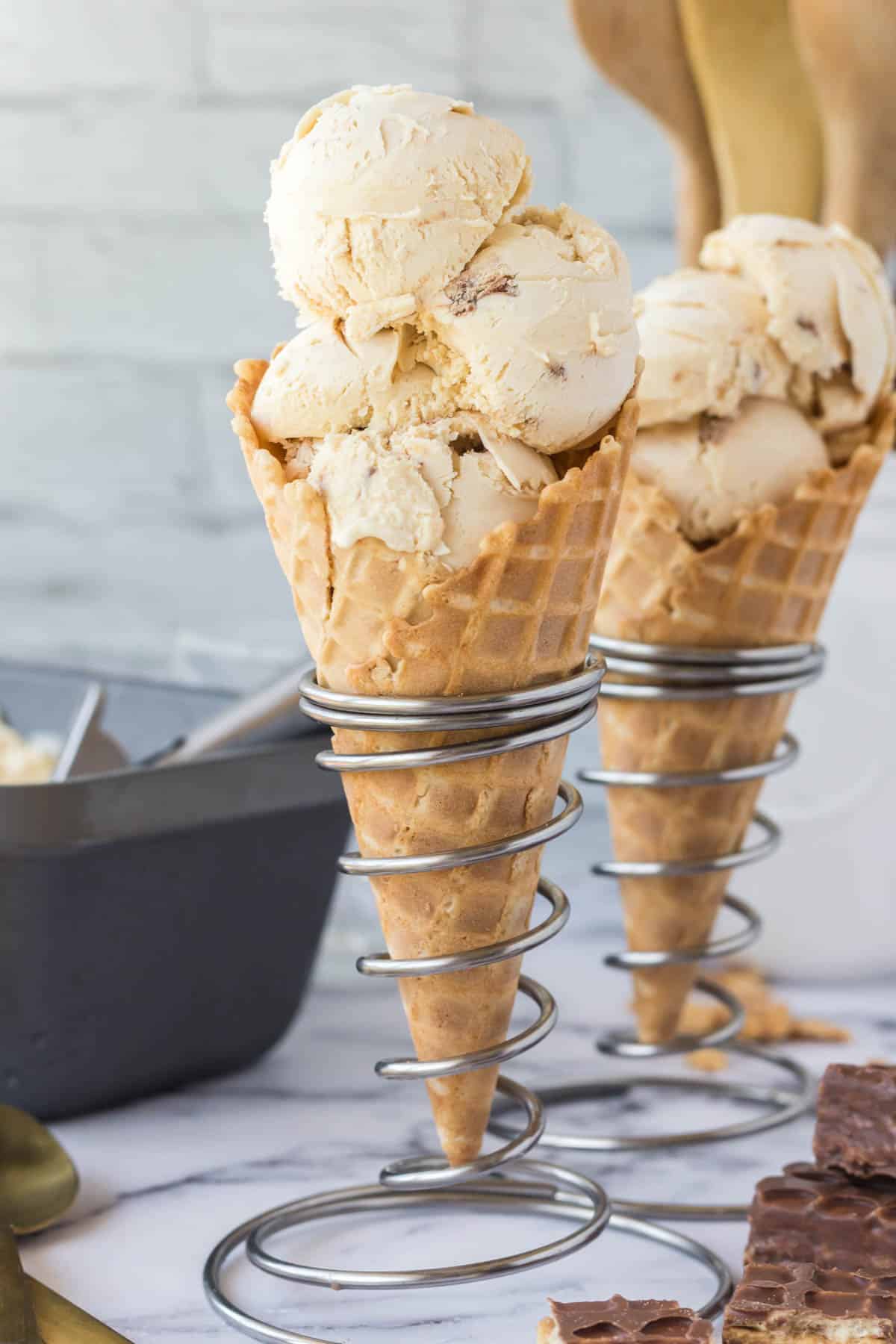 Two nutty buddy waffle ice cream cones on cone stands.