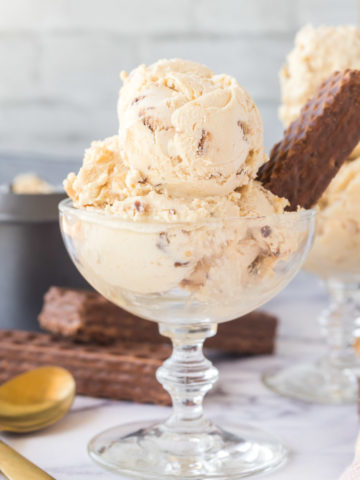 Scoops of nutty buddy ice cream in a glass dessert cup garnished with a nutty buddy.