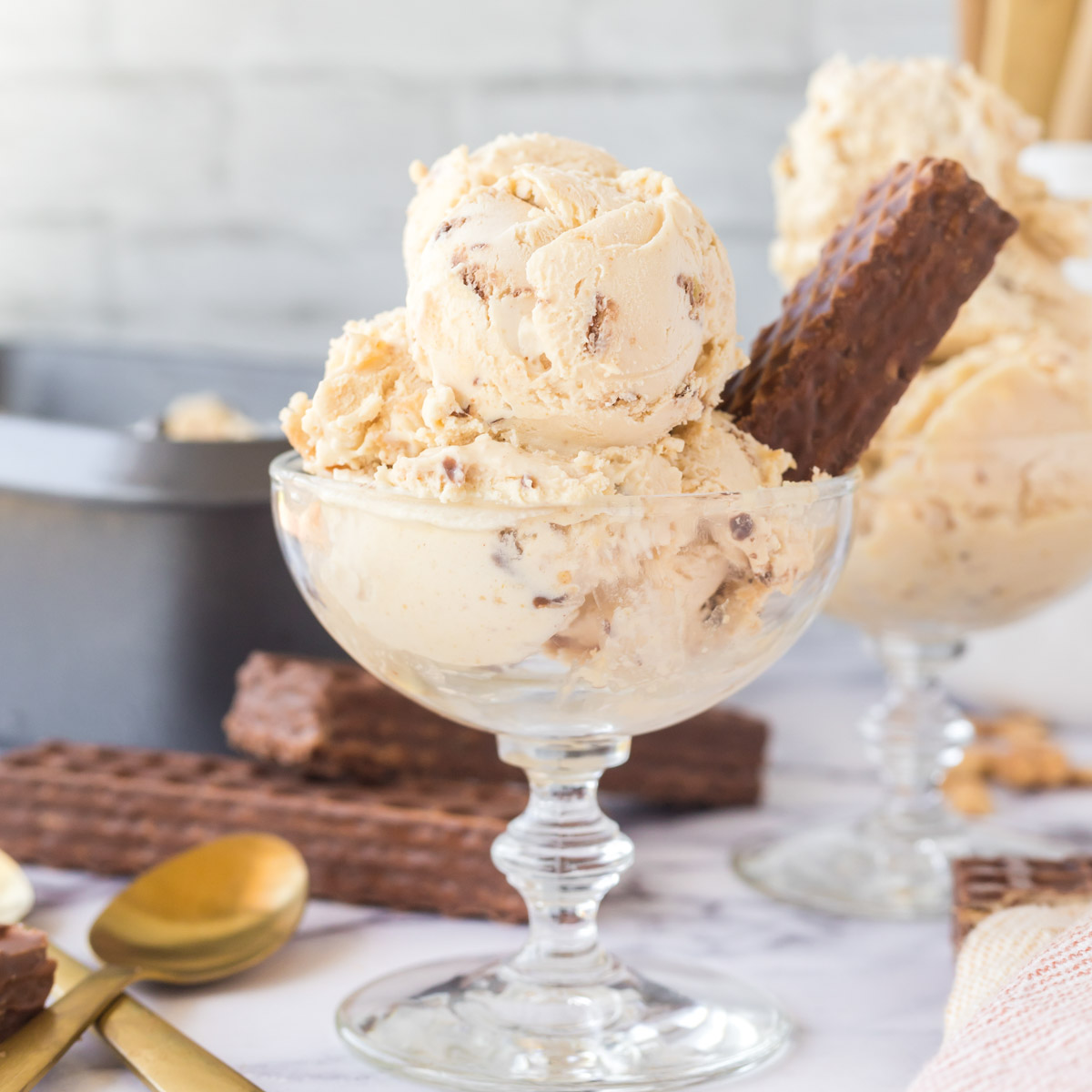 Scoops of nutty buddy ice cream in a glass dessert cup garnished with a nutty buddy.