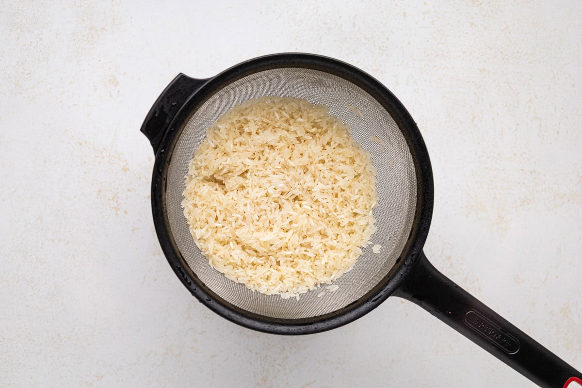 Rice rinsed in a sieve.
