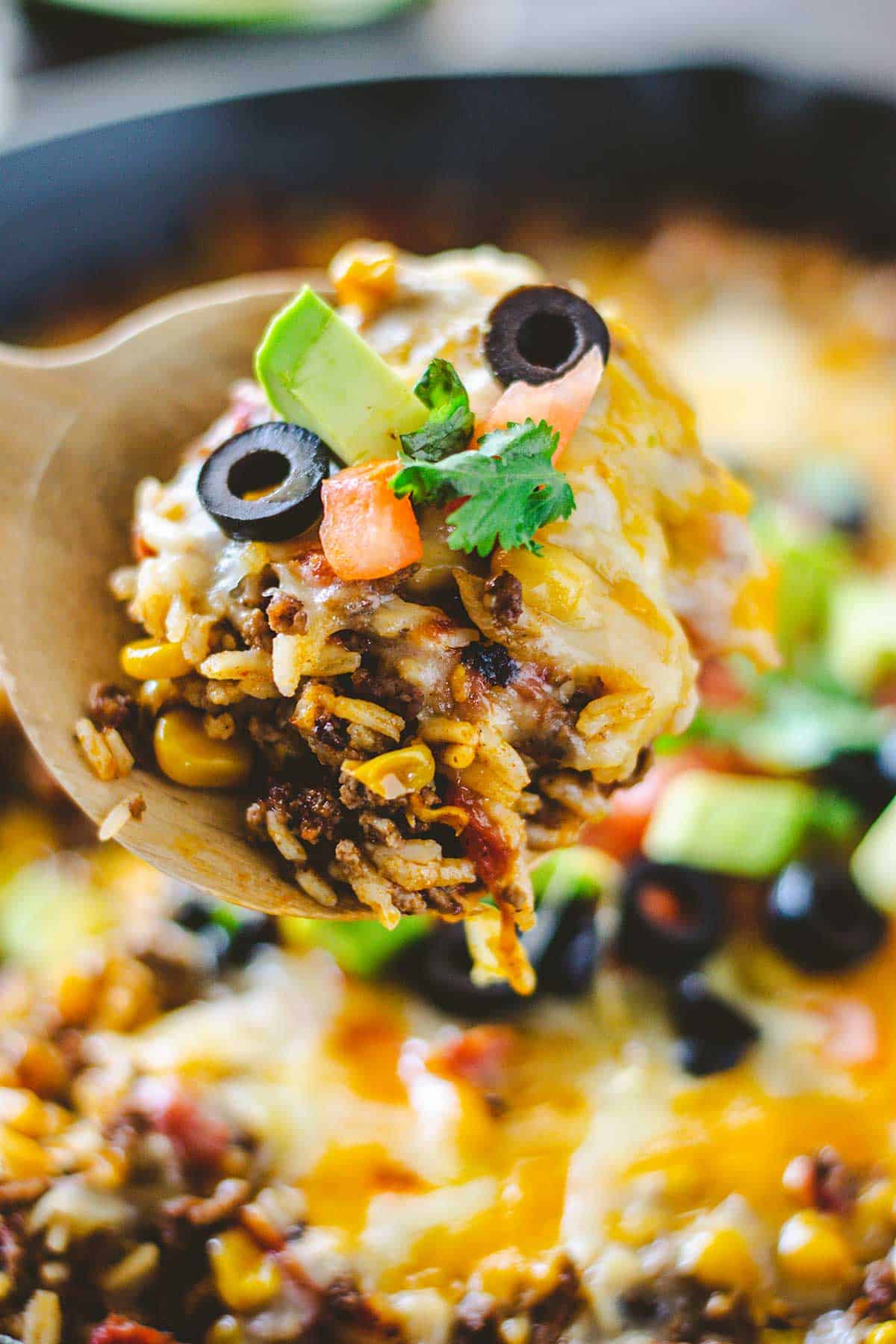 Up close image of a spoon full of mexican rice and beef casserole.