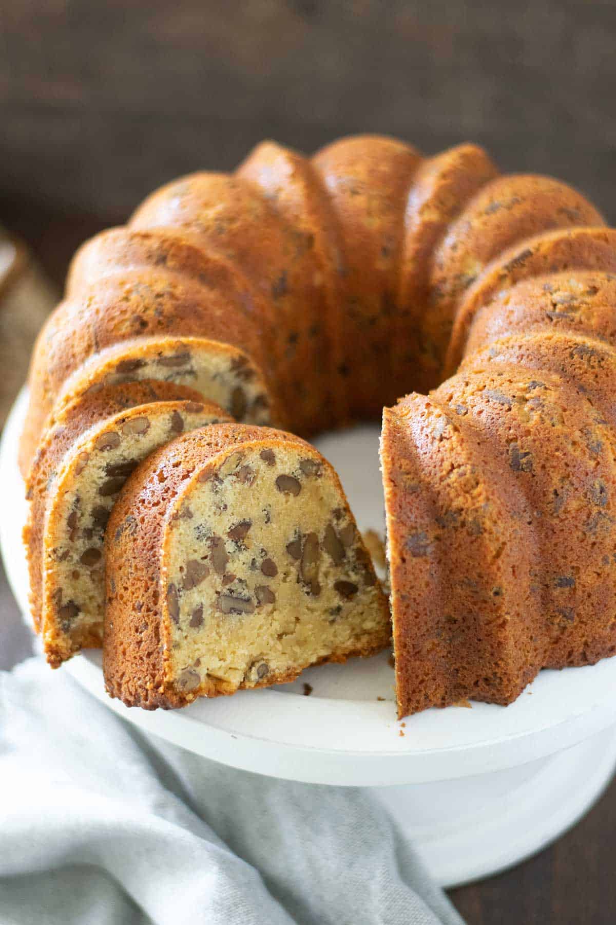 side view of this Southern butter pound cake with a couple slices cut to show interior of cake