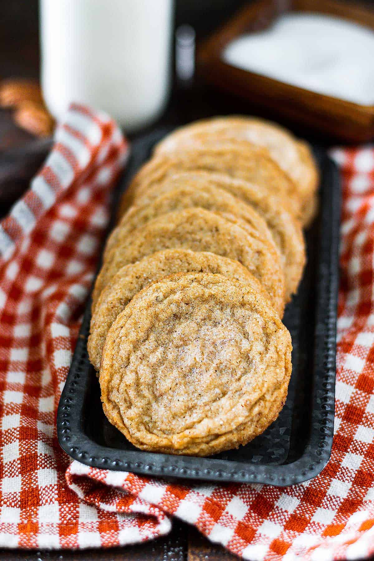 Metal tray with pecan butter cooked set on top with a orange and white checked cloth underneath.