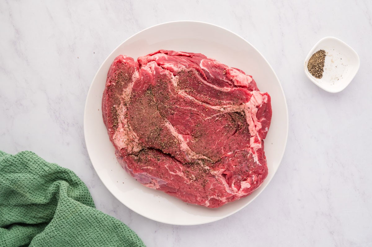 A chuck roast seasoned with black pepper.