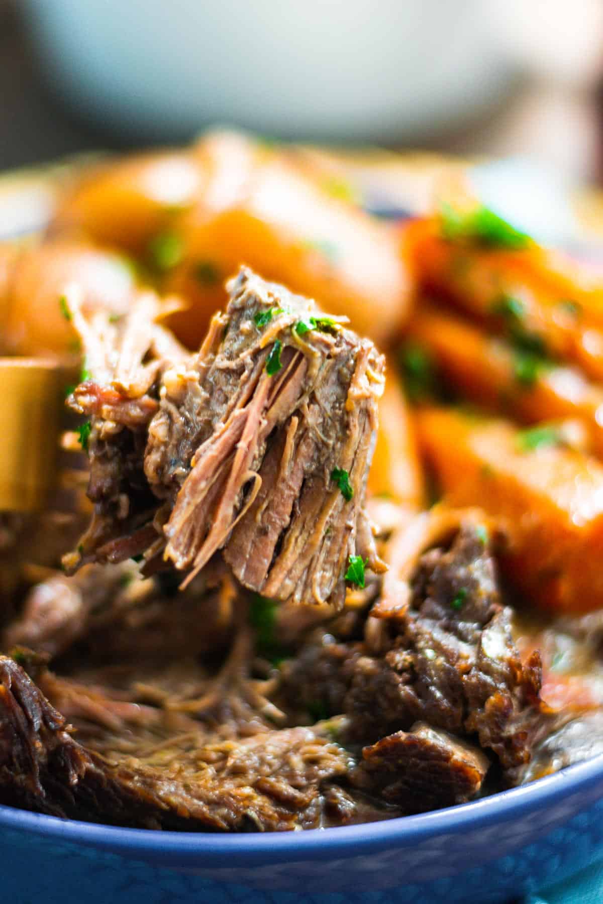 Upclose image of tender pot roast on a fork.