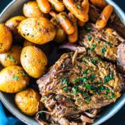 Overhead image of 3-packet pot roast on a serving bowl with carrots and potatoes.