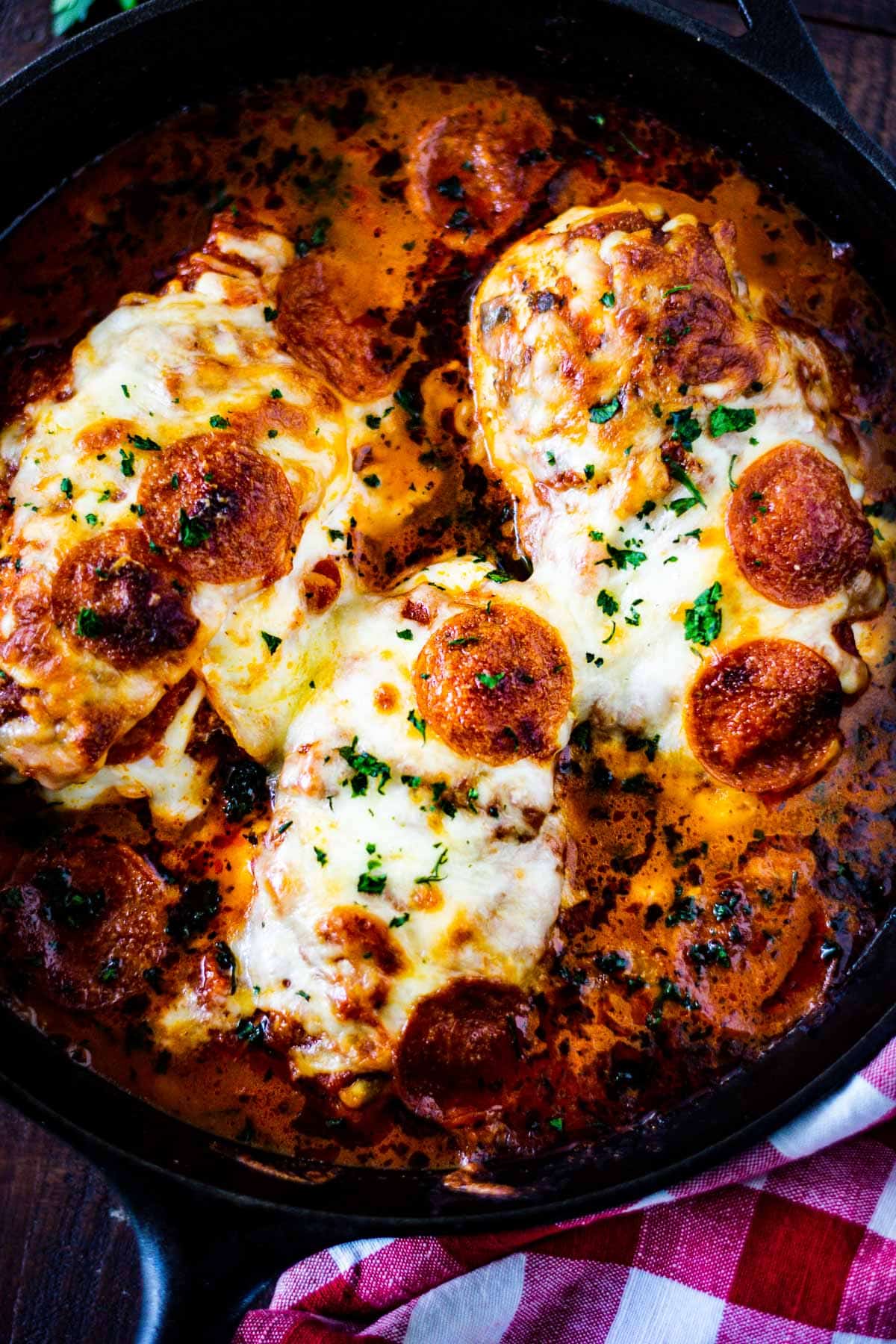 Overhead image of three pizza stuffed chicken breasts in marinara sauce. 