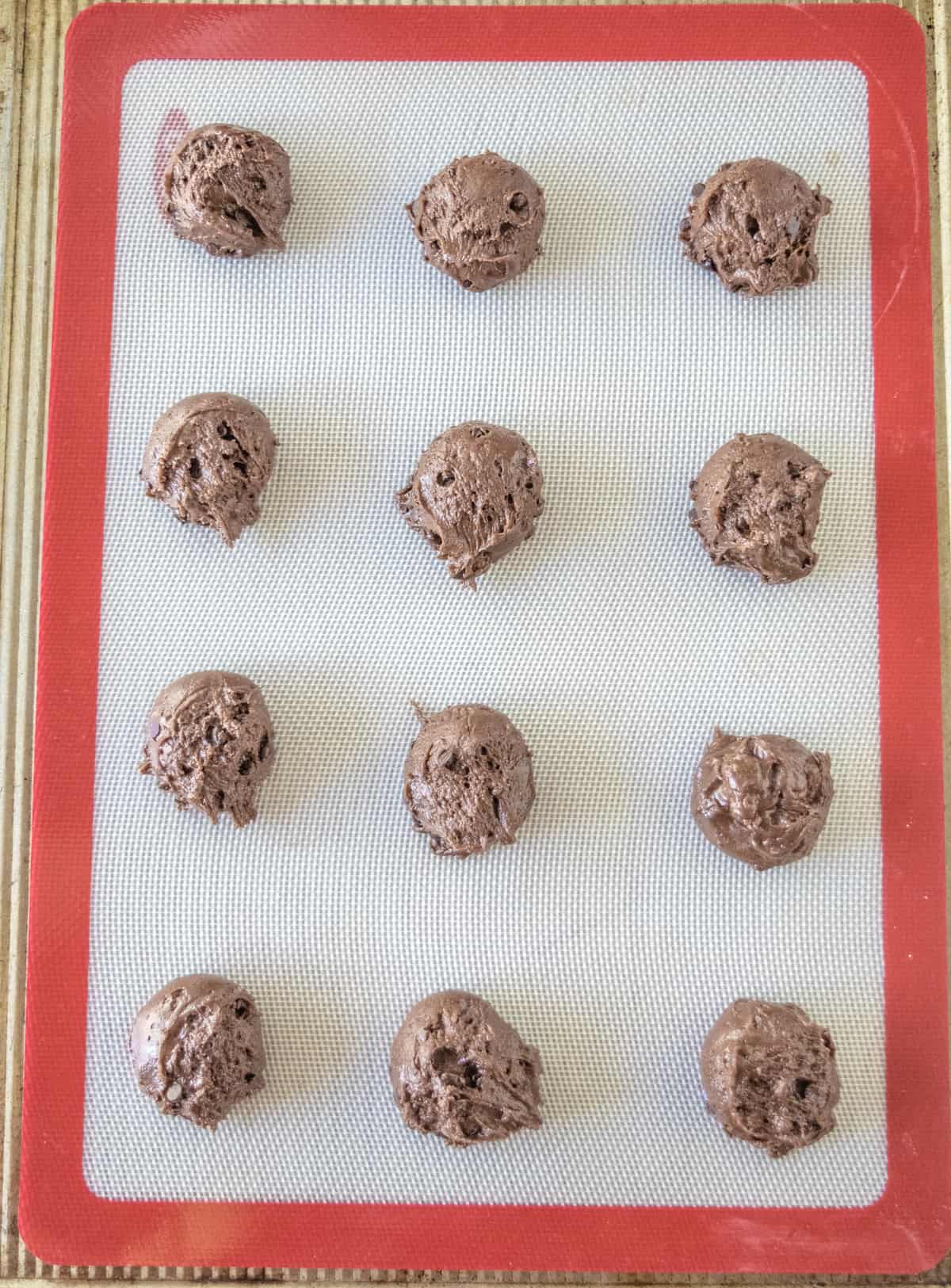 Brownie Cookies scooped with cookie scoop placed on a lined baking sheet.