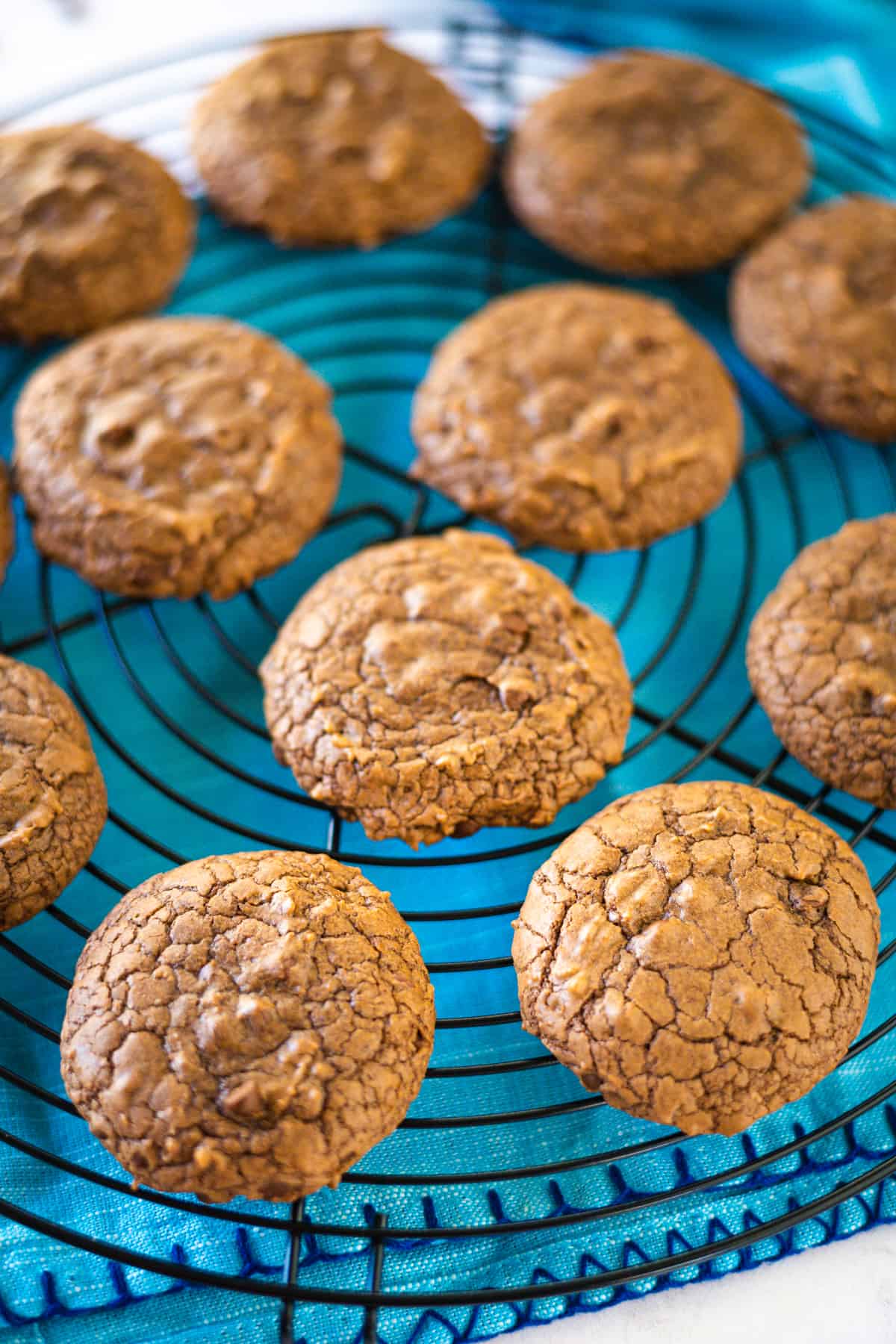 Brownie Cookies on a cooling rack with blue napkin underneath.