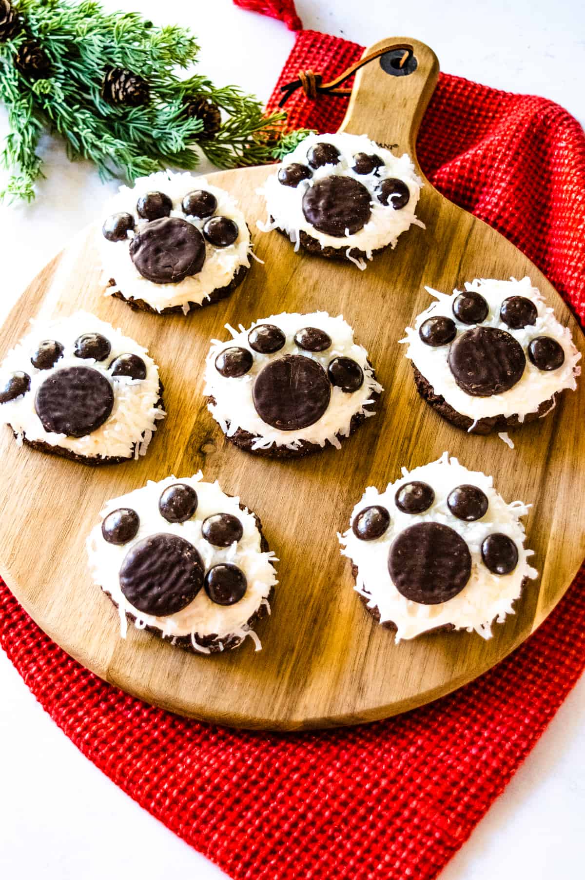 Polar Bear Paw Cookies on a wooden tray with a red cloth backdrop.