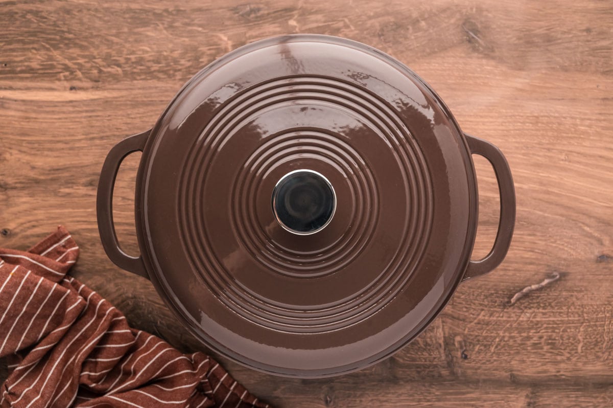 Brown dutch oven covered with lid.